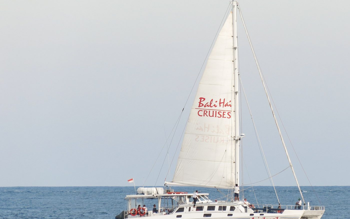 White sailing catamaran on a day cruise in the waters off Bali