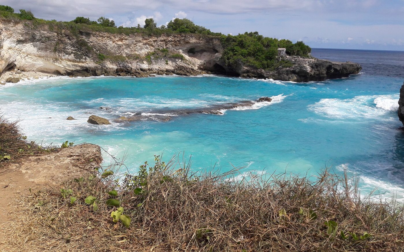 Bright blue lagoon framed by limestone cliffs on Nusa Ceningan next to Nusa Lembongan