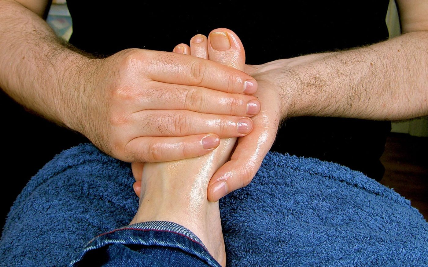Close-up of hands massaging pressure points on a foot