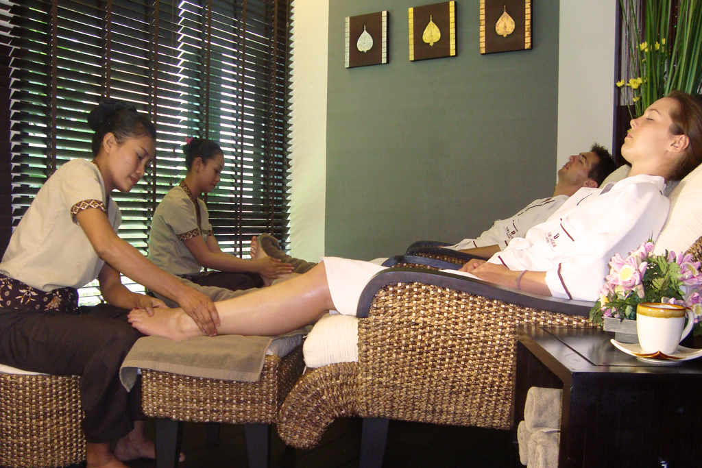 Therapists giving relaxing foot massages to guests in a spa