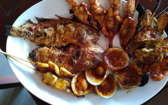 Plate of grilled fish, prawns, clams and squid served at a beach restaurant in Jimbaran