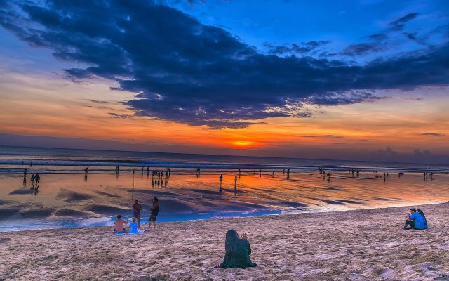 Colourful sunset sky over the wide sandy surf beach at Kuta, Bali