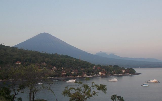 Mount Agung volcano rising above the bay and fishing village of Amed on Bali's east coast
