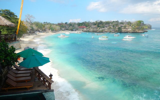 Turquoise water and white sand at Mushroom Bay on Nusa Lembongan with boats moored offshore