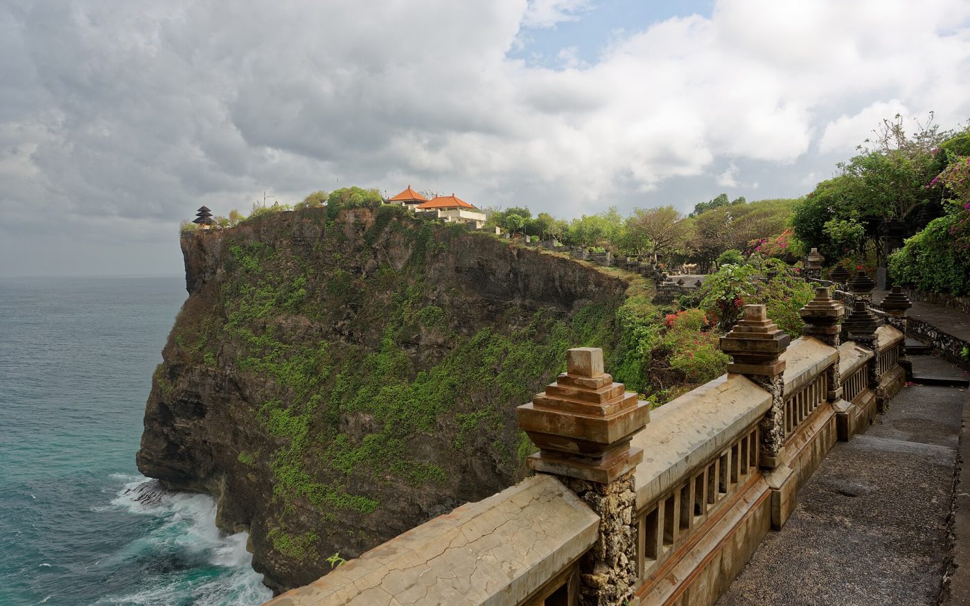 Cliff-top walkway leading towards Pura Luhur Uluwatu temple perched above the Indian Ocean