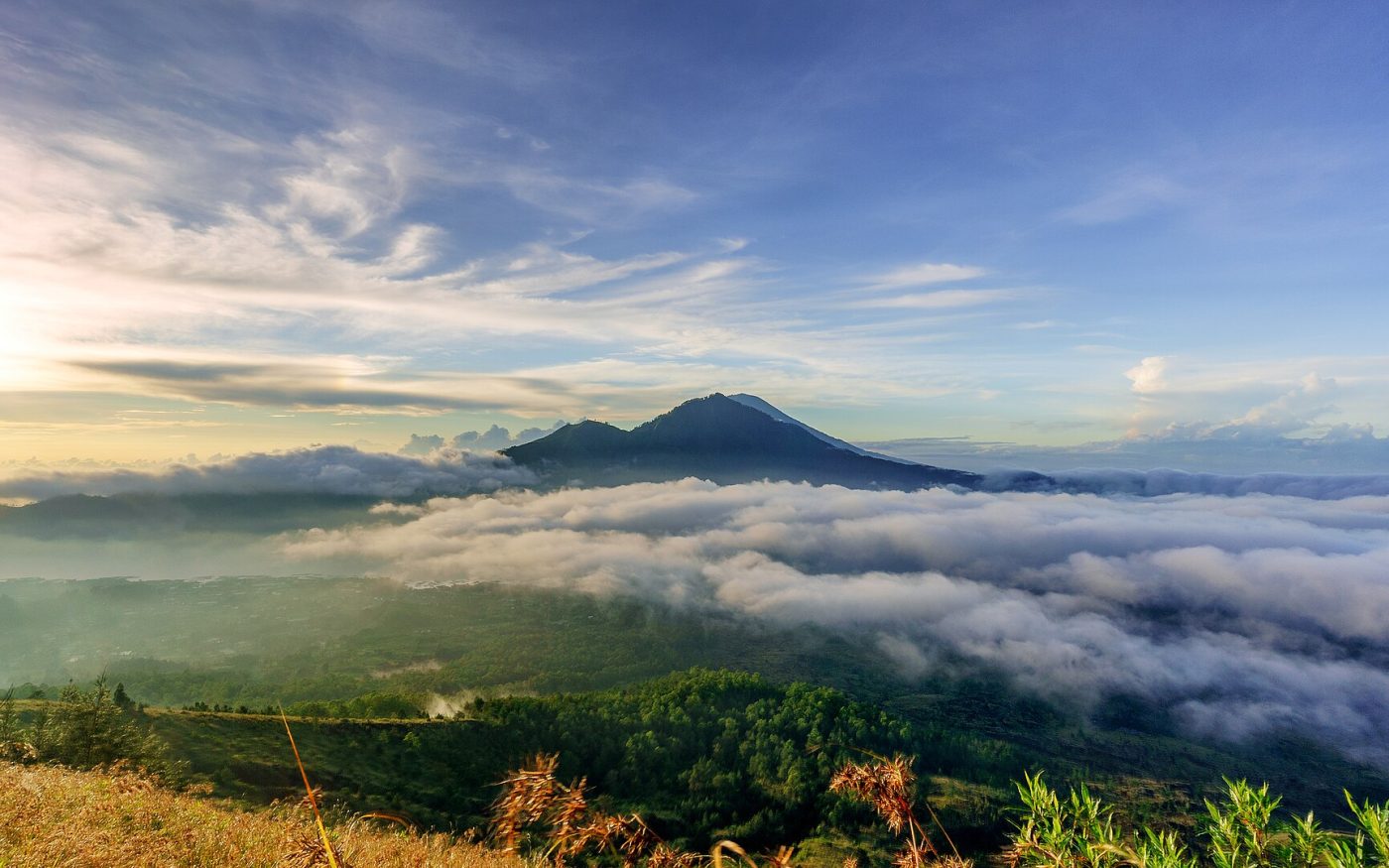 Morning sea of clouds over the Batur caldera with Mount Agung in the distance, seen from the top of Mount Batur