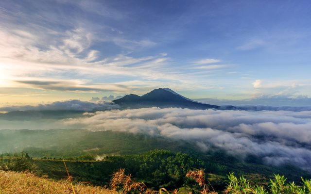 Morning sea of clouds over the Batur caldera with Mount Agung in the distance, seen from the top of Mount Batur