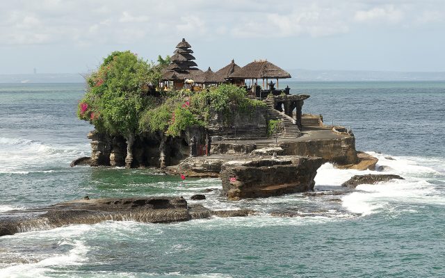 Pura Tanah Lot sea temple on its rock surrounded by waves at high tide