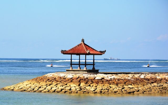 Balinese gazebo on the breakwater at Tanjung Benoa with jet skis on the calm reef-protected water