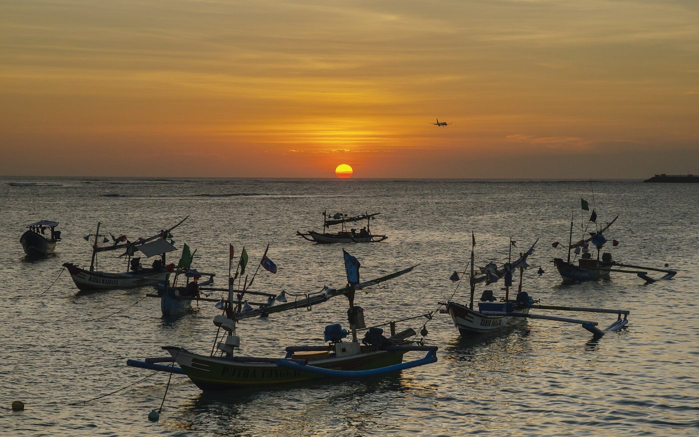 Traditional Balinese fishing boats moored in Kedonganan Bay near Jimbaran at sunset