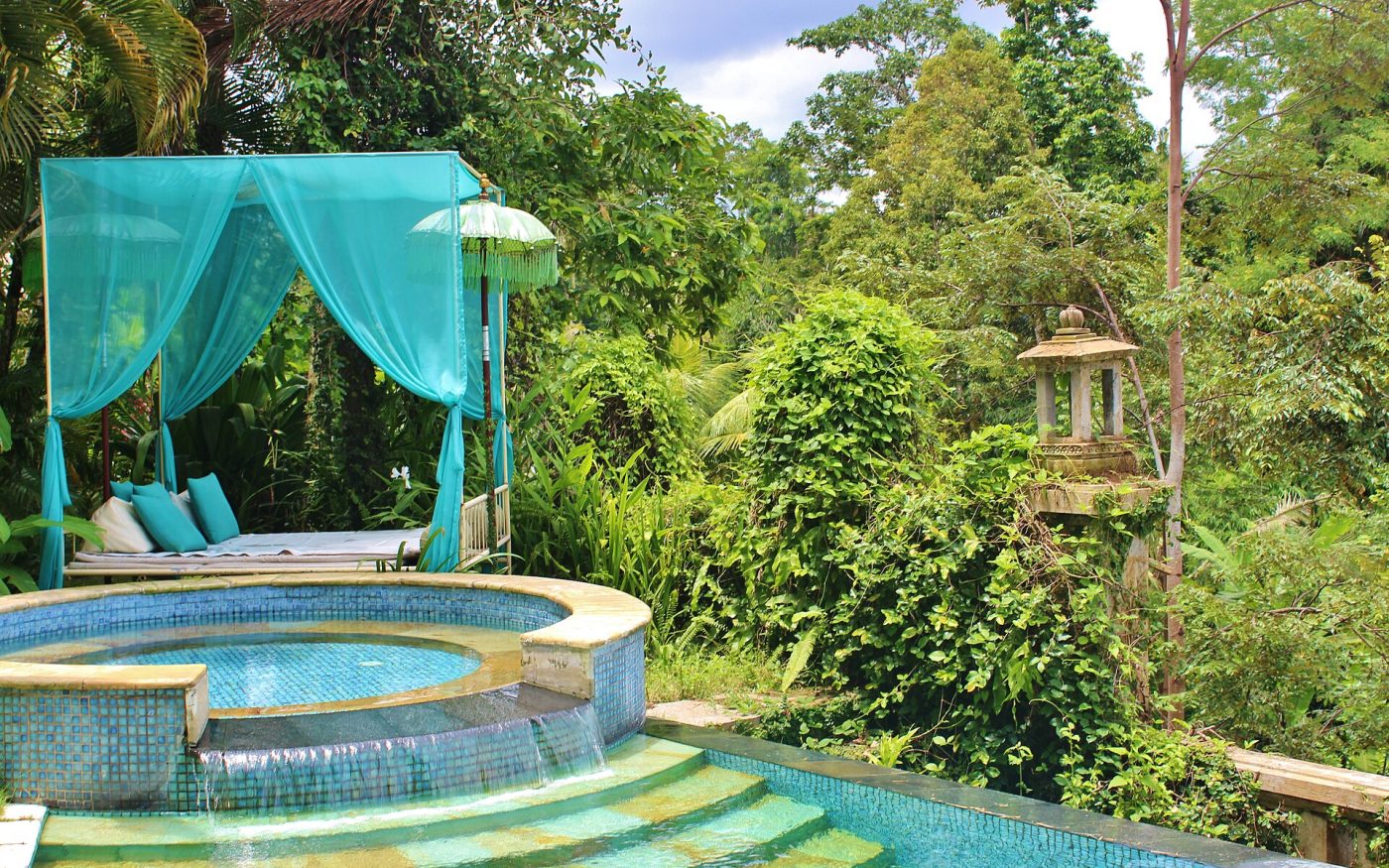 Jungle-side pool and canopy daybed in a tropical garden in Ubud, Bali